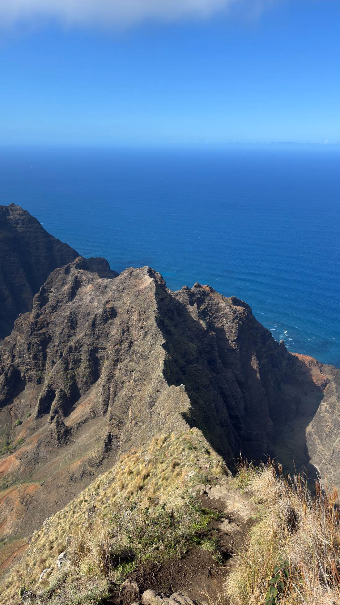 A rocky mountain ridge overlooking a deep blue ocean